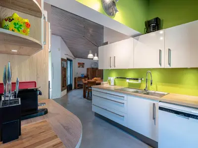 a kitchen with white cabinets and green walls at Villa Villa Romana by Interhome in Porto-Vecchio