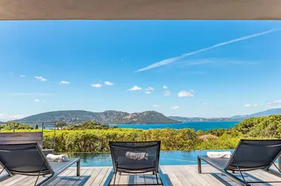 a view of the ocean from the deck of a house at Villa Cala Rossa Di Lecci in Lecci