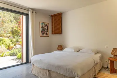 a bedroom with a bed and a large window at Villa Cala Rossa Di Lecci in Lecci