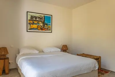 a bedroom with a bed and a picture on the wall at Villa Cala Rossa Di Lecci in Lecci