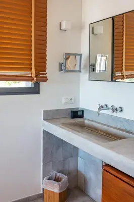 a bathroom with a sink and a mirror at Villa Cala Rossa Di Lecci in Lecci
