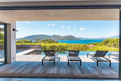 a view of the ocean from the deck of a house at Villa Cala Rossa Di Lecci in Lecci