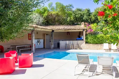a pool with chairs and a kitchen and a house at Villa Trinidad Di Porto-Vecchio in Porto-Vecchio