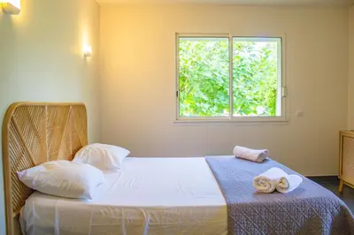 a bedroom with a bed with towels on it at Villa Trinidad Di Porto-Vecchio in Porto-Vecchio
