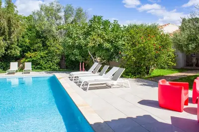 a pool with chaise lounge chairs and a bunch at Villa Trinidad Di Porto-Vecchio in Porto-Vecchio