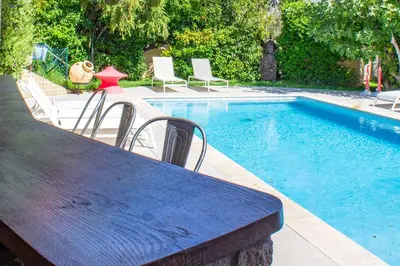 a table and chairs next to a swimming pool at Villa Trinidad Di Porto-Vecchio in Porto-Vecchio