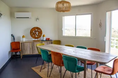 a dining room with a wooden table and chairs at Villa Trinidad Di Porto-Vecchio in Porto-Vecchio