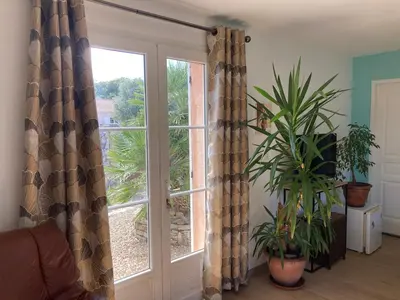 a living room with a window with curtains and plants at Chez Liselotte in Borgo