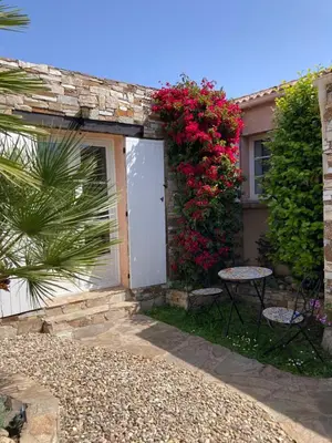 a house with a white door and a table and flowers at Chez Liselotte in Borgo