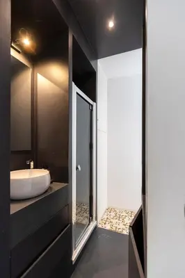 a black bathroom with a sink and a mirror at Les Appartements du Roi de Rome - Hypercentre Ajaccio in Ajaccio
