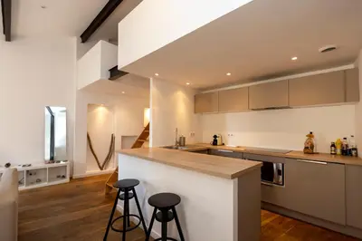 a kitchen with a counter and stools in it at Les Appartements du Roi de Rome - Hypercentre Ajaccio in Ajaccio