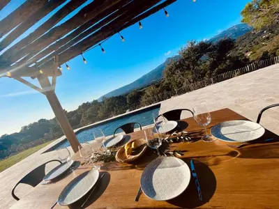 a table with wine glasses and a view of the water at Domaine Aria di Terra***** in Figari