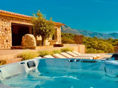 a swimming pool with lounge chairs and a house at Domaine Aria di Terra***** in Figari