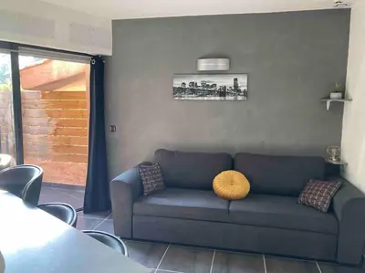a living room with a blue couch with a yellow pillow at Maison SAINTE LUCIE DE PORTO-VECCHIO in Sainte-Lucie de Porto-Vecchio