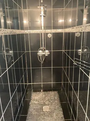 a bathroom with a black and white tiled shower at Maison SAINTE LUCIE DE PORTO-VECCHIO in Sainte-Lucie de Porto-Vecchio