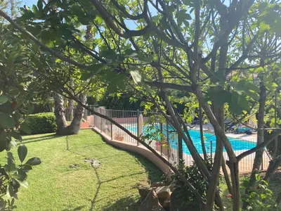 a fence next to a swimming pool in a yard at Maison SAINTE LUCIE DE PORTO-VECCHIO in Sainte-Lucie de Porto-Vecchio