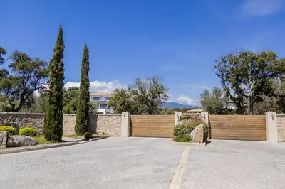 a driveway with a wooden fence and trees at Domaine d'Arca - Flaubert 22 - 3 pièces - étage 2 - Porto-Vecchio in Porto-Vecchio