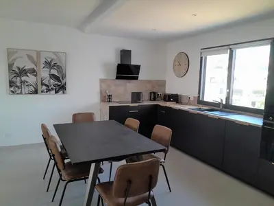 a kitchen and dining room with a table and chairs at Domaine d'Arca - Flaubert 22 - 3 pièces - étage 2 - Porto-Vecchio in Porto-Vecchio