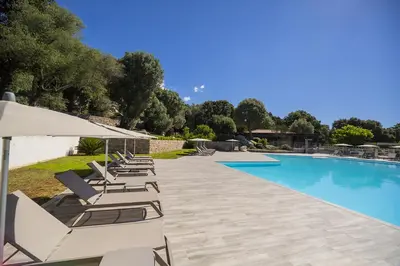 a group of lounge chairs and a swimming pool at Domaine d'Arca - Flaubert 22 - 3 pièces - étage 2 - Porto-Vecchio in Porto-Vecchio