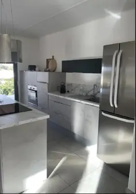 a kitchen with white counters and stainless steel appliances at MONTE LEONE in Bonifacio