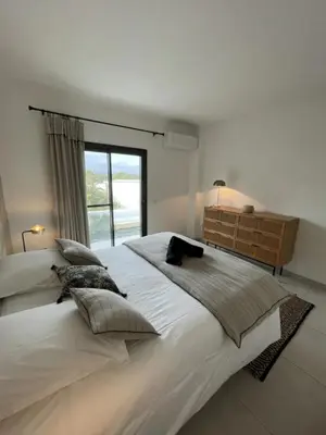 a large white bed in a bedroom with a window at MONTE LEONE in Bonifacio