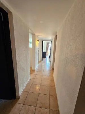 a hallway with a tile floor and white walls and a doorway at Palmeraie 406- vue piscine- clim- proche plage et commerces in Sari Solenzara