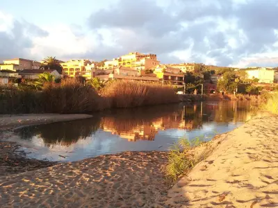 a view of a river with buildings in the background at Palmeraie 406- vue piscine- clim- proche plage et commerces in Sari Solenzara