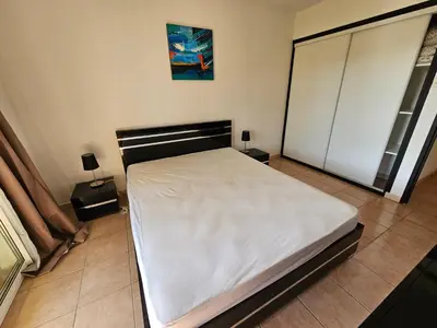 a bedroom with a bed with white sheets on it at Palmeraie 406- vue piscine- clim- proche plage et commerces in Sari Solenzara