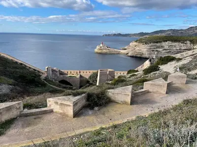 a group of stone benches on a hill near the water at Superbe T2 neuf Bonifacio avec parking gratuit in Bonifacio