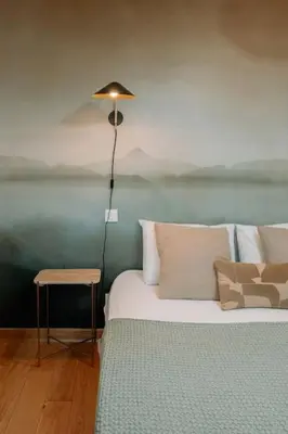a bedroom with a bed with a lamp and a table at Superbe T2 neuf Bonifacio avec parking gratuit in Bonifacio