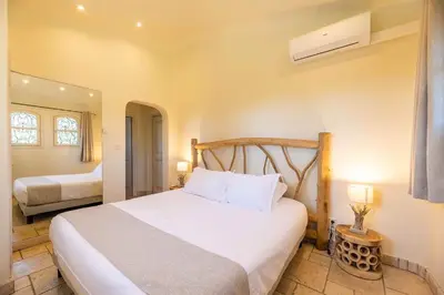 a bedroom with a large bed with white sheets at Magnifique Villa de Luxe avec Piscine in Porto-Vecchio