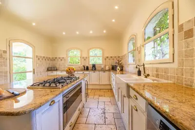 a large kitchen with white cabinets and windows at Magnifique Villa de Luxe avec Piscine in Porto-Vecchio