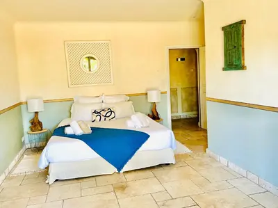 a bedroom with a large white bed with blue sheets at Magnifique Villa de Luxe avec Piscine in Porto-Vecchio