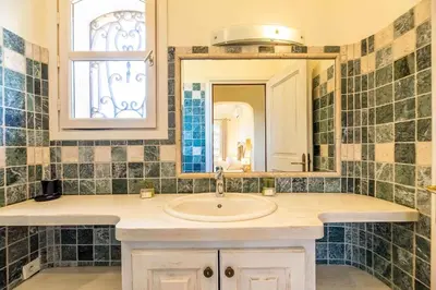 a bathroom with a sink and a mirror at Magnifique Villa de Luxe avec Piscine in Porto-Vecchio