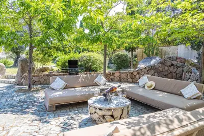 a patio with a couch and a table and trees at Magnifique Villa de Luxe avec Piscine in Porto-Vecchio