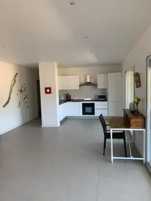 a living room with a table and a kitchen at Grand T4 , vue magnifique à 50 m de la plage in Propriano
