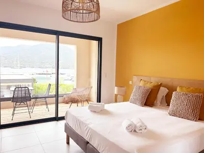 a bedroom with a large bed with towels on it at Hôtel A Stretta in Propriano