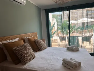 a bed with towels on it with a large window at Hôtel A Stretta in Propriano