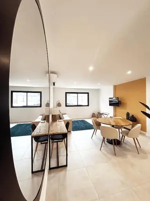 a living room with a table and chairs and a mirror at Hôtel A Stretta in Propriano