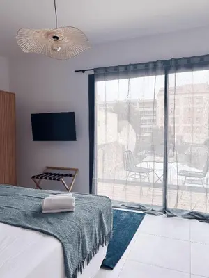 a bedroom with a bed and a large window at Hôtel A Stretta in Propriano