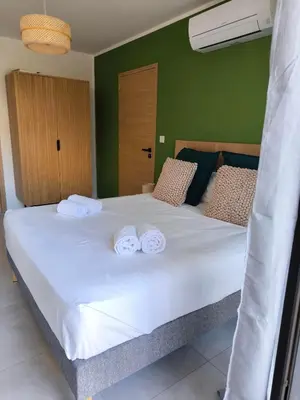a bedroom with a large white bed with towels on it at Hôtel A Stretta in Propriano