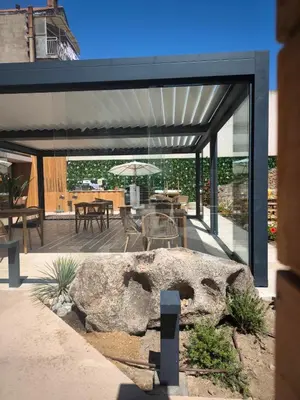 a house with a glass extension with a rock at Hôtel A Stretta in Propriano