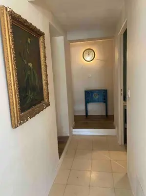 a hallway with a painting on the wall and a table at Rez de chaussée villa avec piscine in Piana