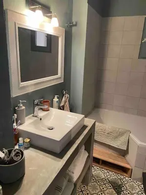 a bathroom with a sink and a mirror and a tub at Rez de chaussée villa avec piscine in Piana