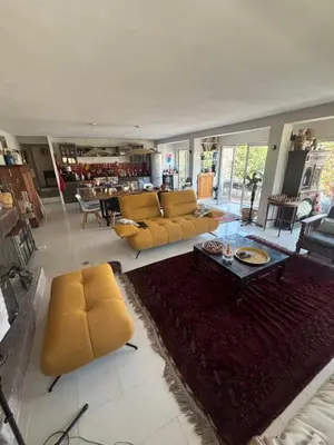 a living room with yellow couches and a table at Rez de chaussée villa avec piscine in Piana