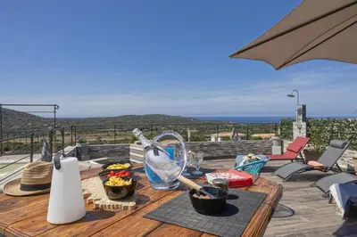 a wooden table with food on top of a patio at Villa Les 2 F plage de Losari - Belgodère in Belgodère