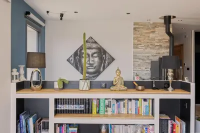 a book shelf with books and a statue on it at Villa Les 2 F plage de Losari - Belgodère in Belgodère