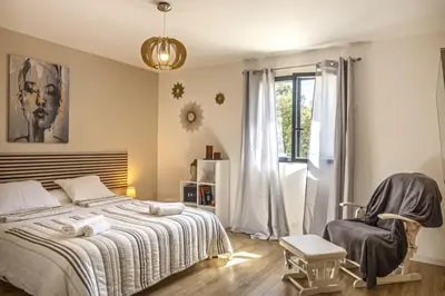 a bedroom with a bed and a chair and a window at Villa Les 2 F plage de Losari - Belgodère in Belgodère