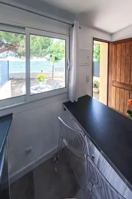 a kitchen with a black counter and a window at Holiday Home Dentice by Interhome in Sari Solenzara