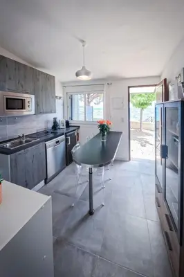 a kitchen with a table in the middle of it at Holiday Home Dentice by Interhome in Sari Solenzara